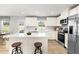 Bright kitchen with white cabinets, stainless steel appliances, center island with seating, and wood-look floors at 220 Rosewood Dr, Sanford, NC 27330