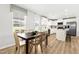 Open kitchen with white cabinets, stainless steel appliances, and a dark table with six chairs at 220 Rosewood Dr, Sanford, NC 27330