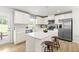 Modern kitchen featuring white cabinets, stainless steel appliances, an island with seating, and wood flooring at 220 Rosewood Dr, Sanford, NC 27330