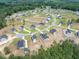 A lush green forest surrounds an aerial view of neighborhood with modern homes and green spaces at 224 Wild Turkey Way, Lillington, NC 27546