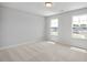 Carpeted bedroom with a view of the neighborhood from two windows letting in natural light at 224 Wild Turkey Way, Lillington, NC 27546