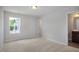 Bedroom featuring a carpeted floor, a window and access to the bathroom at 224 Wild Turkey Way, Lillington, NC 27546