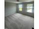 A bedroom bathed in natural light showcases two windows and plush neutral carpeting at 224 Wild Turkey Way, Lillington, NC 27546
