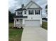 Charming two-story home with a two-car garage, white siding, and an American flag at 224 Wild Turkey Way, Lillington, NC 27546