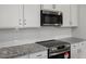 Close-up of a kitchen showcasing granite countertops, stainless steel appliances, and white backsplash at 224 Wild Turkey Way, Lillington, NC 27546