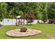 This backyard has a swing sitting area and fire pit surrounded by lush green grass and white fencing at 229 Hocutt Farm Dr Dr, Clayton, NC 27527