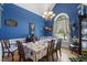 Formal dining room with blue walls, elegant chandelier, and large window offering natural light at 229 Hocutt Farm Dr Dr, Clayton, NC 27527