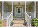 Inviting front porch with rocking chairs, potted plants, and a decorative door, creating a warm welcome at 229 Hocutt Farm Dr Dr, Clayton, NC 27527