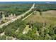 Aerial view of a property showing the house, pool, and surrounding lush greenery along a major highway at 25 Misty Way, Franklinton, NC 27525