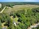 Aerial view of a home, pool and clearing amongst the trees showing a large lot with beautiful landscaping at 25 Misty Way, Franklinton, NC 27525