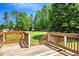 Wooden deck with railing overlooks a sprawling, well-manicured lawn and landscaped backyard at 25 Misty Way, Franklinton, NC 27525