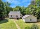Backyard view of the house and detached structure surrounded by green grass, with a stone path at 25 Misty Way, Franklinton, NC 27525