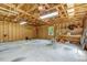 Spacious two-car garage with exposed wooden ceiling and concrete flooring offers ample storage and workspace at 25 Misty Way, Franklinton, NC 27525