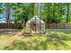 Lovely greenhouse in a lush backyard, perfect for gardening enthusiasts and growing plants year-round at 25 Misty Way, Franklinton, NC 27525