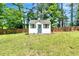 Charming shed with a blue door and window, nestled in a green backyard with a wood fence at 25 Misty Way, Franklinton, NC 27525