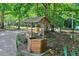 Rustic wooden wishing well surrounded by lush foliage adds a touch of charm to the landscape at 25 Misty Way, Franklinton, NC 27525