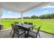 Covered patio with outdoor dining set offering picturesque views of the expansive backyard and green space at 30 Elmwood Ave, Sanford, NC 27330