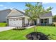 Beautiful new home with manicured lawn, stone accents, two car garage, and a young crape myrtle tree at 30 Elmwood Ave, Sanford, NC 27330