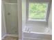 Well-lit bathroom features separate glass shower, soaking tub and large window at 3021 Remington Oaks Cir, Cary, NC 27519