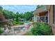 Beautiful backyard patio with stone fire pit and seating area, surrounded by lush gardens and overlooking the pool house at 3197 Carriage Creek Ct, Haw River, NC 27258