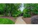 Landscaped backyard with stone walkway, mature trees, and well-maintained lawn at 3197 Carriage Creek Ct, Haw River, NC 27258