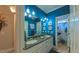 A blue bathroom features a double vanity, large mirror, and ample lighting, leading to the toilet and shower at 3197 Carriage Creek Ct, Haw River, NC 27258