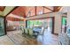 The dining room table is set and ready for a meal, looking out to the outdoor pool with a wood beam ceiling at 3197 Carriage Creek Ct, Haw River, NC 27258