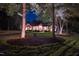 Stunning brick home at night with professional lighting highlighting the manicured lawn and mature trees at 3197 Carriage Creek Ct, Haw River, NC 27258
