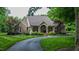 Beautiful brick home features a circular driveway, manicured lawn, and a covered front porch with stately columns at 3197 Carriage Creek Ct, Haw River, NC 27258
