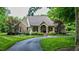 Charming brick home with a columned porch, manicured lawn, and curved driveway nestled among mature trees at 3197 Carriage Creek Ct, Haw River, NC 27258