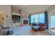 Cozy living room with a fireplace, built-in media center, and large windows that provide plenty of natural light at 3197 Carriage Creek Ct, Haw River, NC 27258