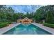Inviting pool view, reflecting the beautifully lit patio and open-air structure, ideal for relaxation and gatherings at 3197 Carriage Creek Ct, Haw River, NC 27258