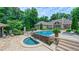 A luxurious pool and hot tub surrounded by stone walls in a brick home's backyard create a relaxing retreat at 3197 Carriage Creek Ct, Haw River, NC 27258
