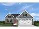 Charming home featuring gray siding, stone accents, and a two-car garage at 32 Elmwood Ave, Sanford, NC 27330