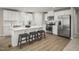 Bright, modern kitchen with white cabinets, stainless steel appliances, and a spacious island with seating at 32 Elmwood Ave, Sanford, NC 27330
