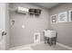 Functional laundry room with a utility sink, storage shelf, tile floor, and neutral walls at 32 Elmwood Ave, Sanford, NC 27330