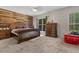 Serene bedroom features a wood accent wall, a large window, and neutral decor to offer relaxation at 3841 Rawls Church Rd, Fuquay Varina, NC 27526