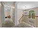 Bright hallway featuring a chandelier, staircase and a large arched window at the end of the hall at 3841 Rawls Church Rd, Fuquay Varina, NC 27526
