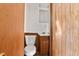 Bathroom featuring a white toilet, vanity, medicine cabinet, and wood-paneled walls at 403 S Webb St, Selma, NC 27576