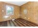 Bedroom with wood-paneled walls, hardwood floors, and window offering views of the surroundings at 403 S Webb St, Selma, NC 27576