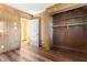 Cozy bedroom with wood-paneled walls, hardwood floors, and closet with wooden shelving at 403 S Webb St, Selma, NC 27576