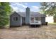 Backyard home view featuring a chimney, blue siding, gray roof, and a wooden upper deck at 5008 Dantonville Ct, Knightdale, NC 27545