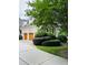 Three-car garage on a white brick house with wood doors and professional landscaping at 5205 Newstead Manor Ln, Raleigh, NC 27606