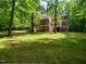 Lush green backyard with view of a brick home, balcony, and screened in porch at 540 Vista Del Lago Ln, Wake Forest, NC 27587