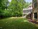 Backyard view of a brick home featuring a screened porch, balcony, and luscious lawn at 540 Vista Del Lago Ln, Wake Forest, NC 27587