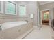 Relaxing bathroom featuring a large soaking tub with jets, neutral tiling, and bright windows at 540 Vista Del Lago Ln, Wake Forest, NC 27587