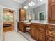 Bathroom with dual sink vanity, granite countertop, framed mirror, custom cabinets and an open door to the bedroom at 540 Vista Del Lago Ln, Wake Forest, NC 27587