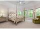 Bright bedroom with a large four-poster bed, sitting chair, and plenty of natural light at 540 Vista Del Lago Ln, Wake Forest, NC 27587