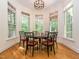 Bright breakfast nook with large windows and a stylish chandelier over a round wooden table at 540 Vista Del Lago Ln, Wake Forest, NC 27587