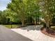 Scenic view of a long driveway winding toward a brick home, surrounded by lush greenery at 540 Vista Del Lago Ln, Wake Forest, NC 27587